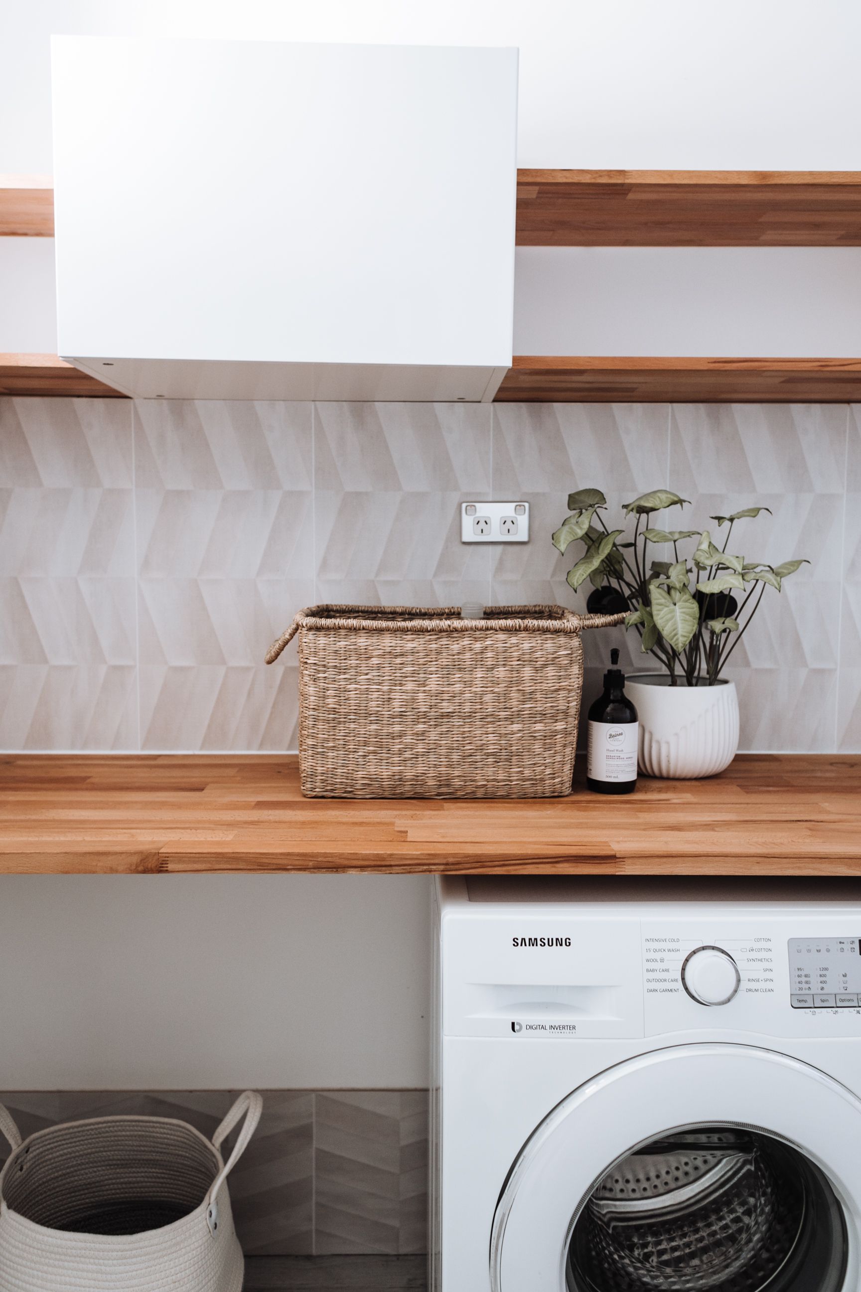 An ordinary home laundry with a washing machine and laundry baskets